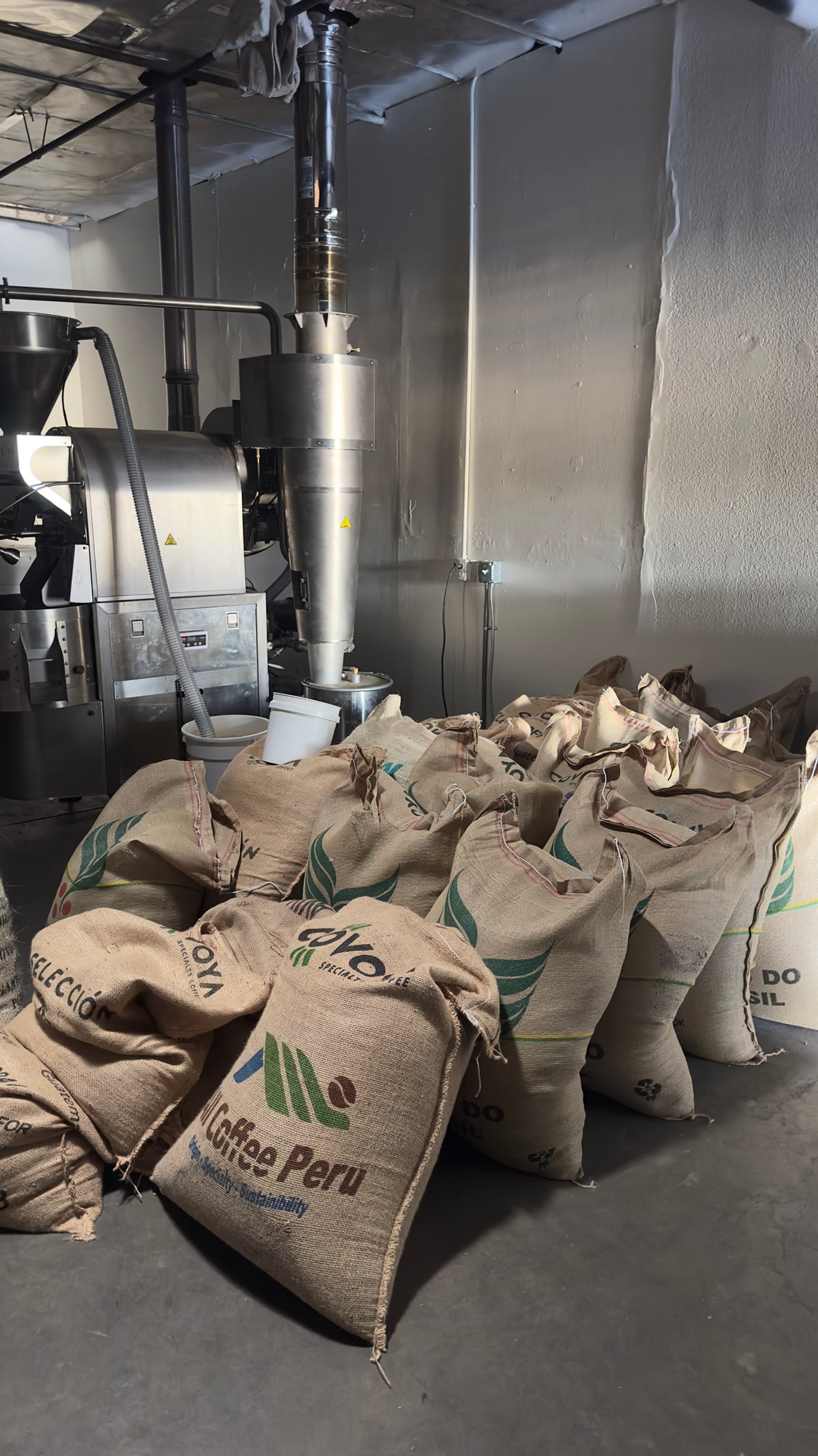 Bags of green coffee inside the Clay Coffee roastery