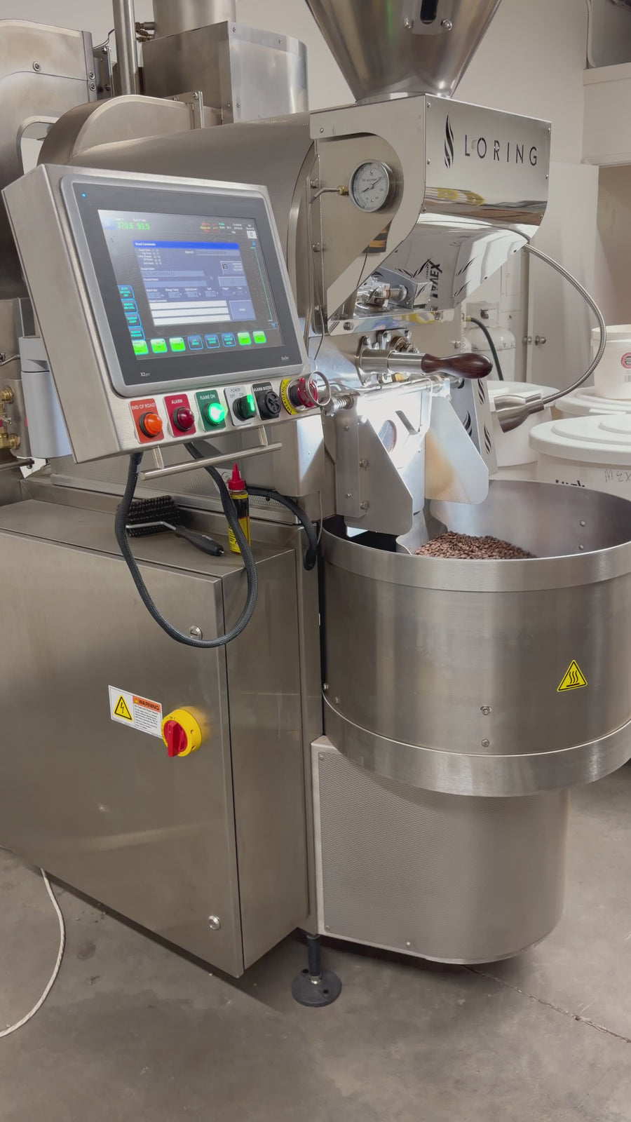 Roasted coffee beans moving in the cooling tray beneath the Loring roaster at Clay Coffee.